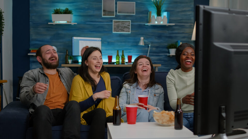 multiracial-friends-laughing-together-while-sitting-couch